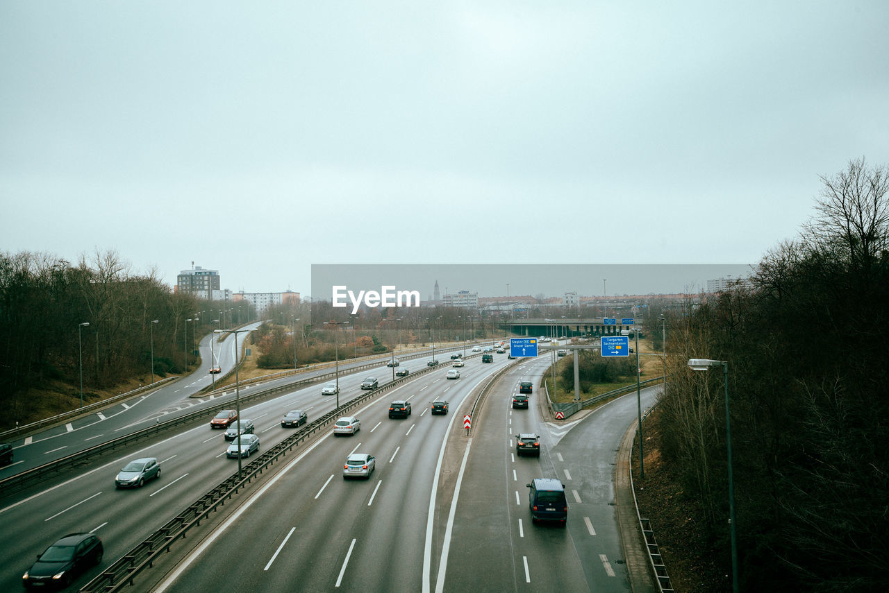 High angle view of vehicles on highways seen from bridge against sky