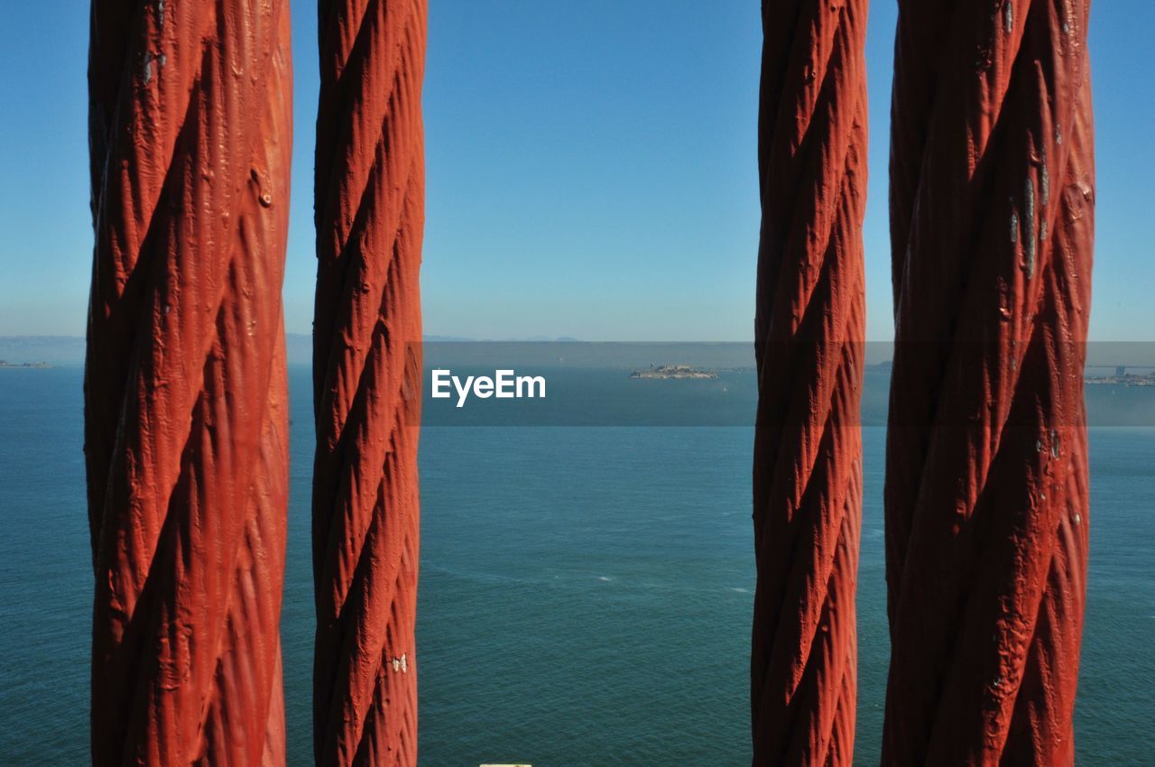 Close-up of red golden gate bridge steel cables against san francisco bay