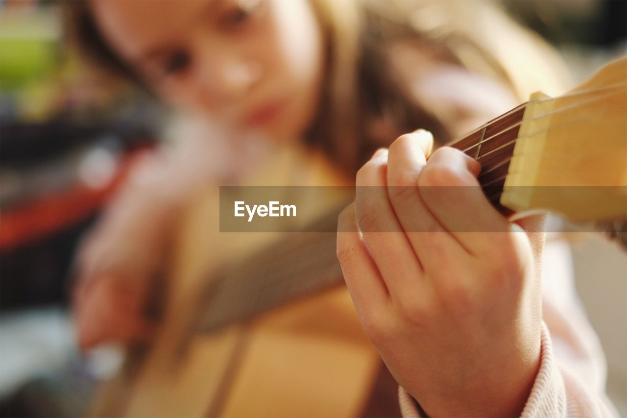 Close-up of girl playing guitar