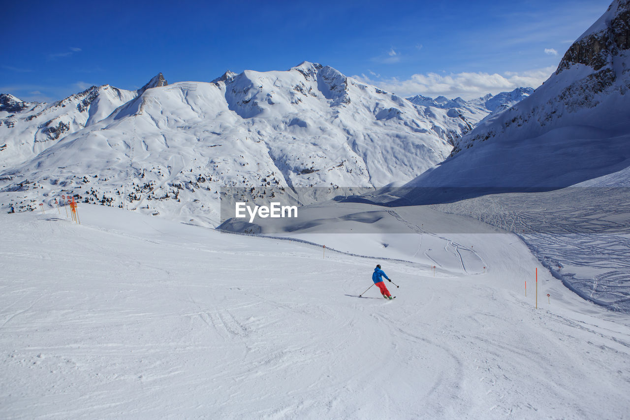 Men skiing on snowcapped mountain against sky