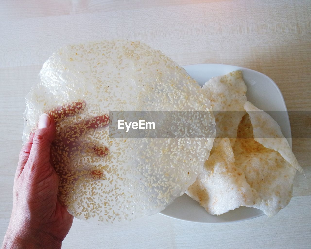 Cropped image of hand holding rice paper