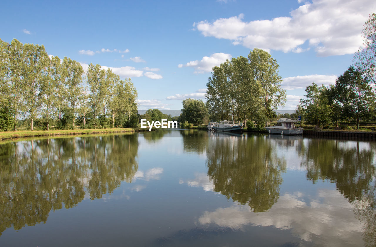 reflection, water, tree, lake, nature, plant, sky, beauty in nature, tranquility, scenics - nature, cloud, body of water, autumn, tranquil scene, no people, environment, landscape, travel destinations, outdoors, reservoir, blue, leaf, day, reflection lake, non-urban scene, travel, tourism, summer, idyllic, forest, architecture