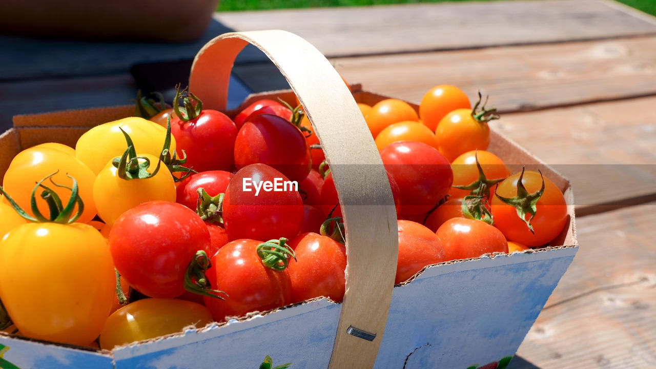 food and drink, food, tomato, healthy eating, fruit, vegetable, freshness, plant, produce, wellbeing, wood, red, container, yellow, no people, nature, plum tomato, box, close-up, large group of objects, day, multi colored, sunlight, outdoors, basket, focus on foreground