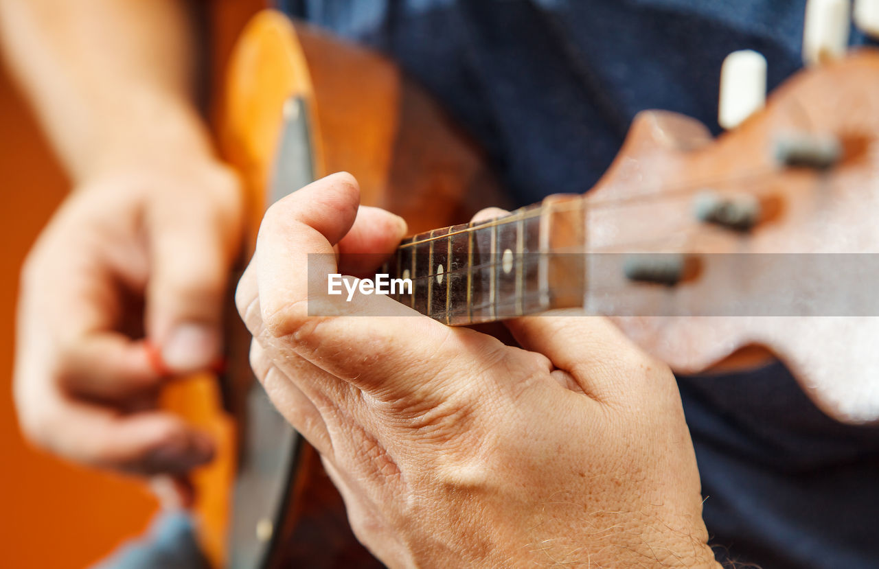 Midsection of man playing string instrument