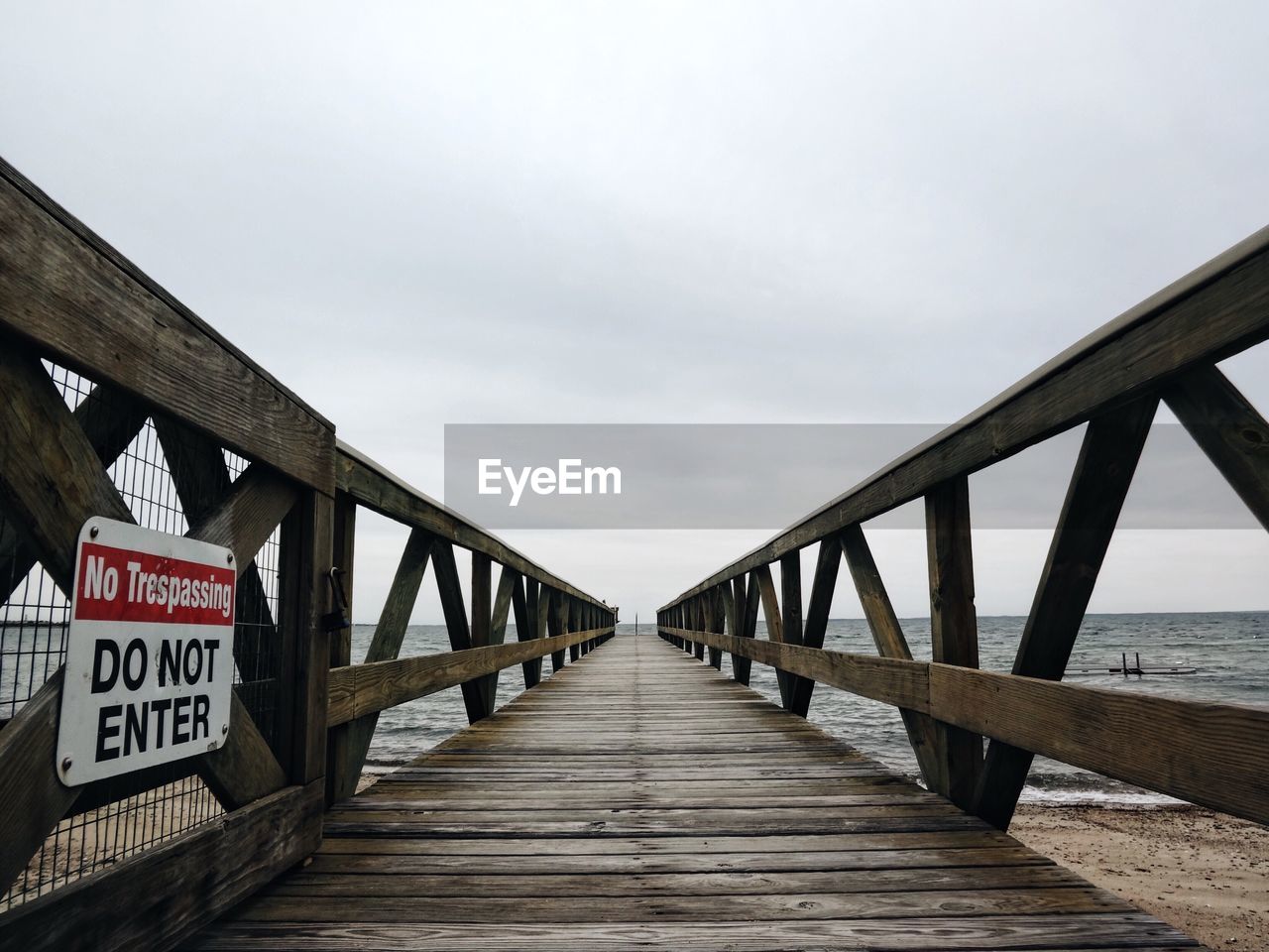 Pier over sea against cloudy sky