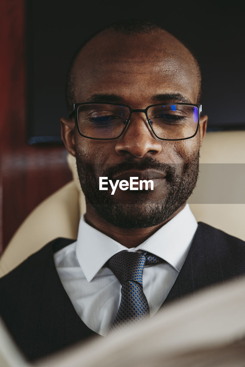 Young businessman with eyeglasses in private jet