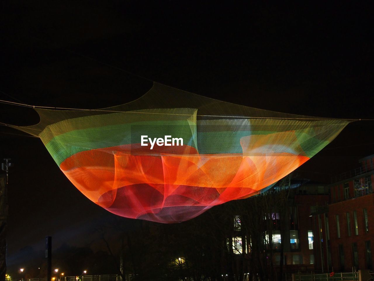 Colorful fabric decoration hanging in city at night