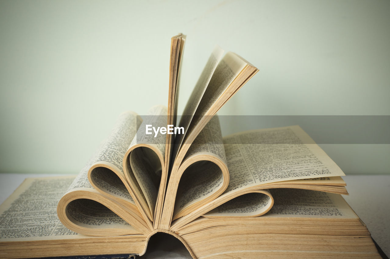 CLOSE-UP OF BOOK ON TABLE