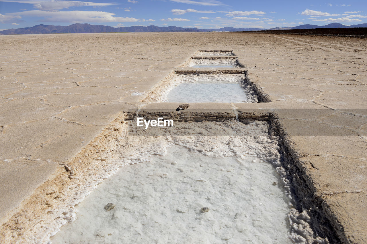 View of desert against cloudy sky