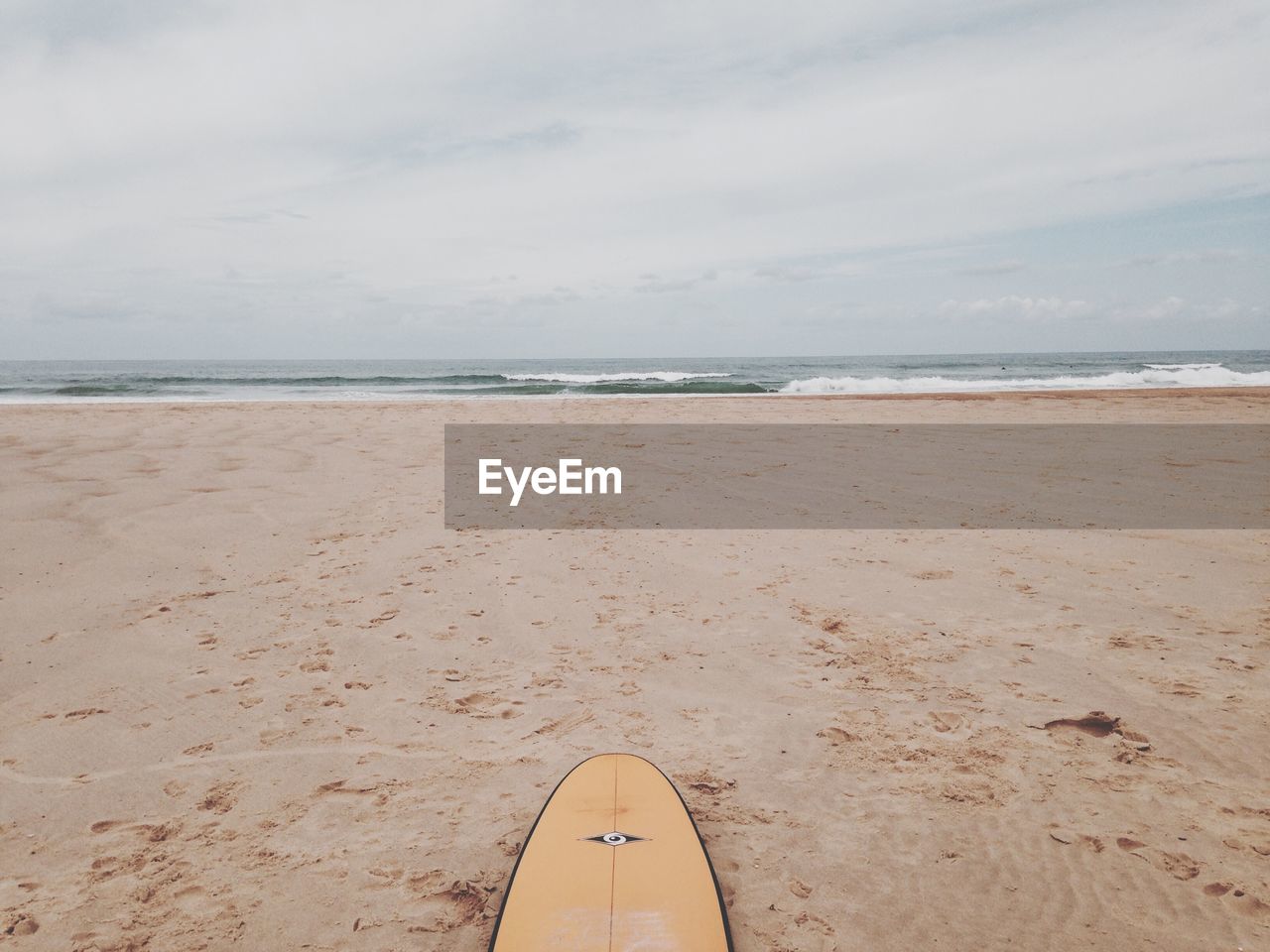 Surfboard on beach against sky