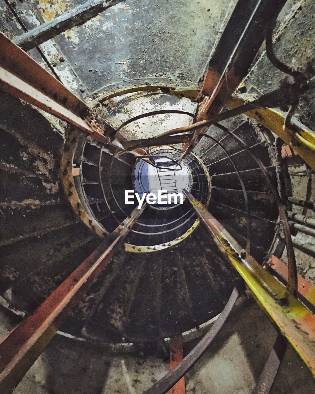 architecture, no people, metal, staircase, built structure, indoors, railing, high angle view, steps and staircases, day, old, directly above, spiral, rusty, spiral staircase, transportation, close-up, mode of transportation, abandoned, wheel