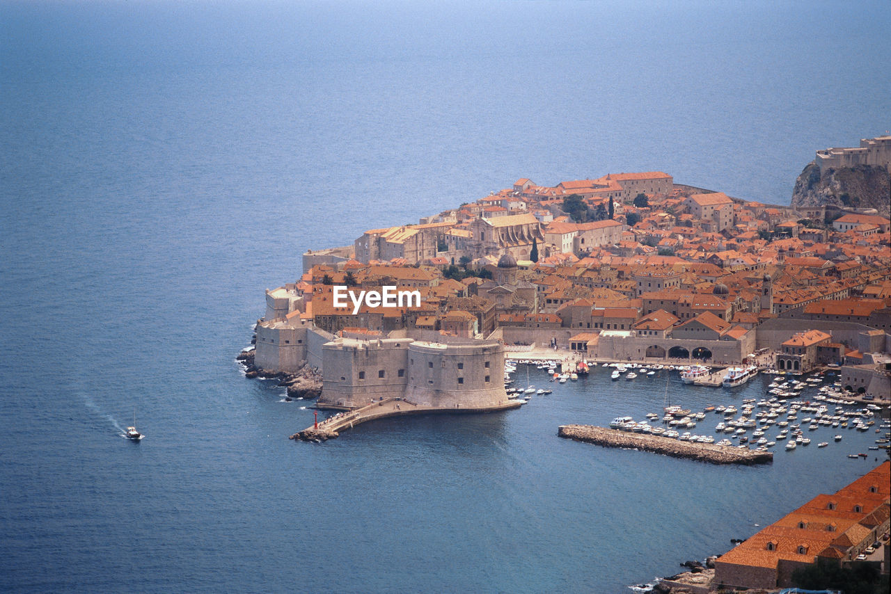 Aerial view of cityscape by sea against sky