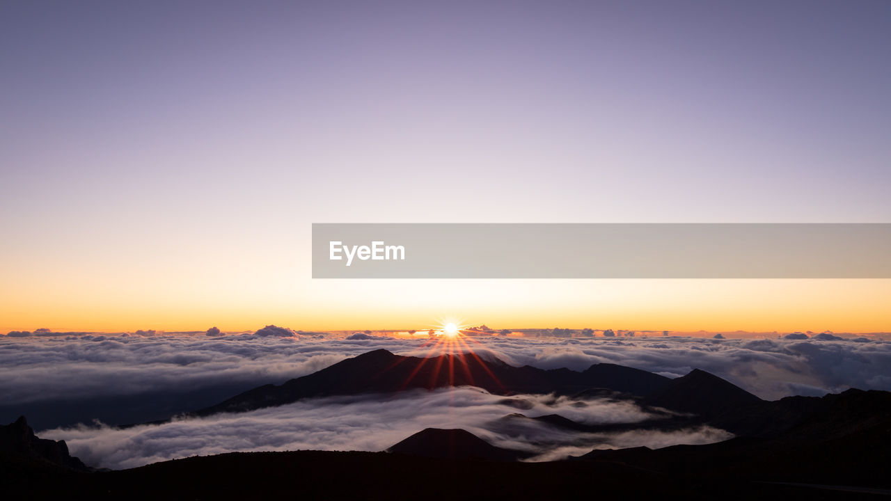 Scenic view of snowcapped mountains against sky during sunset