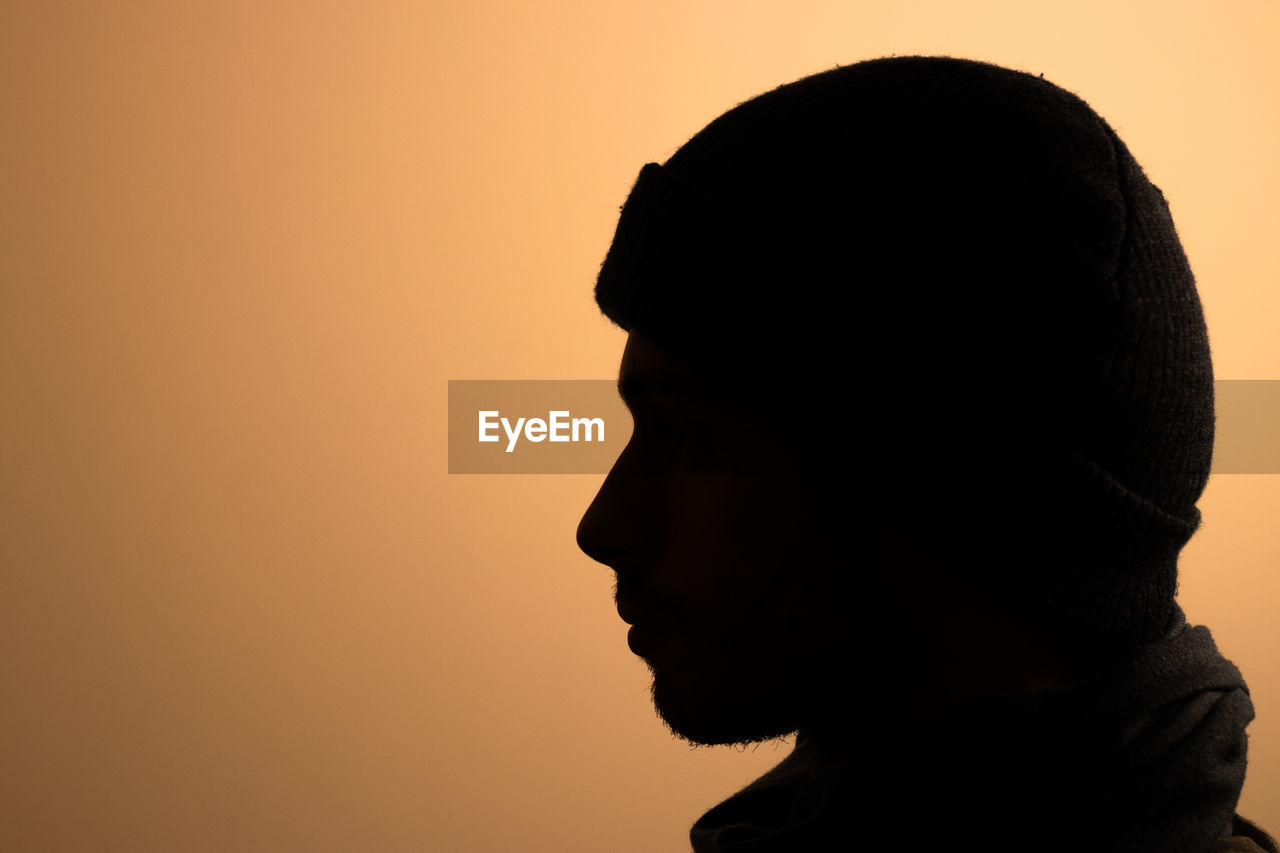 Close-up of silhouette man against orange sky