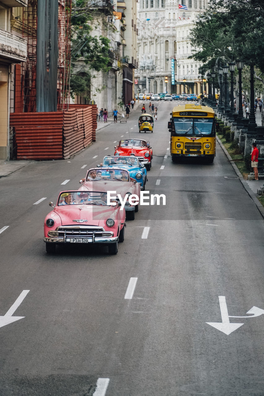 VEHICLES ON ROAD ALONG BUILDINGS