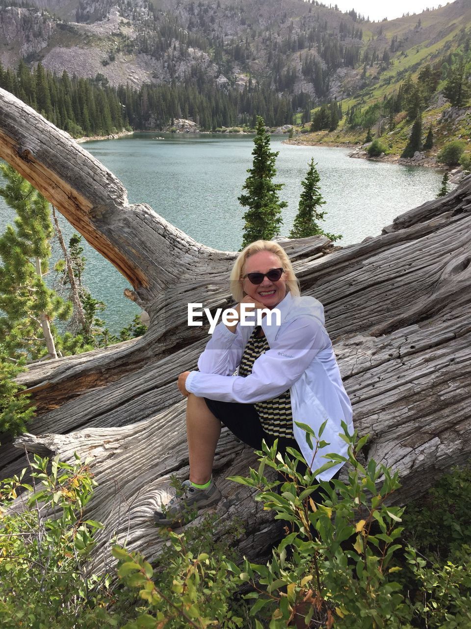 Portrait of woman sitting in front of lake