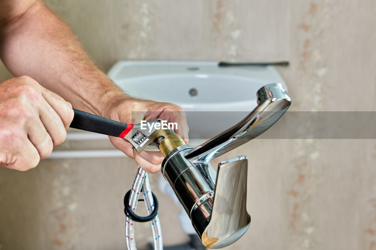 cropped hand of man washing hands