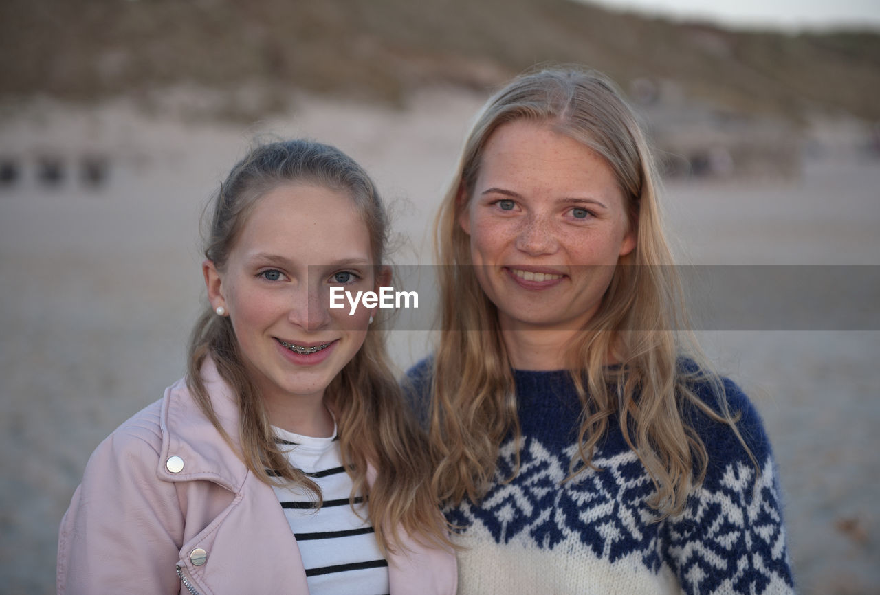 Portrait of smiling sisters standing outdoors