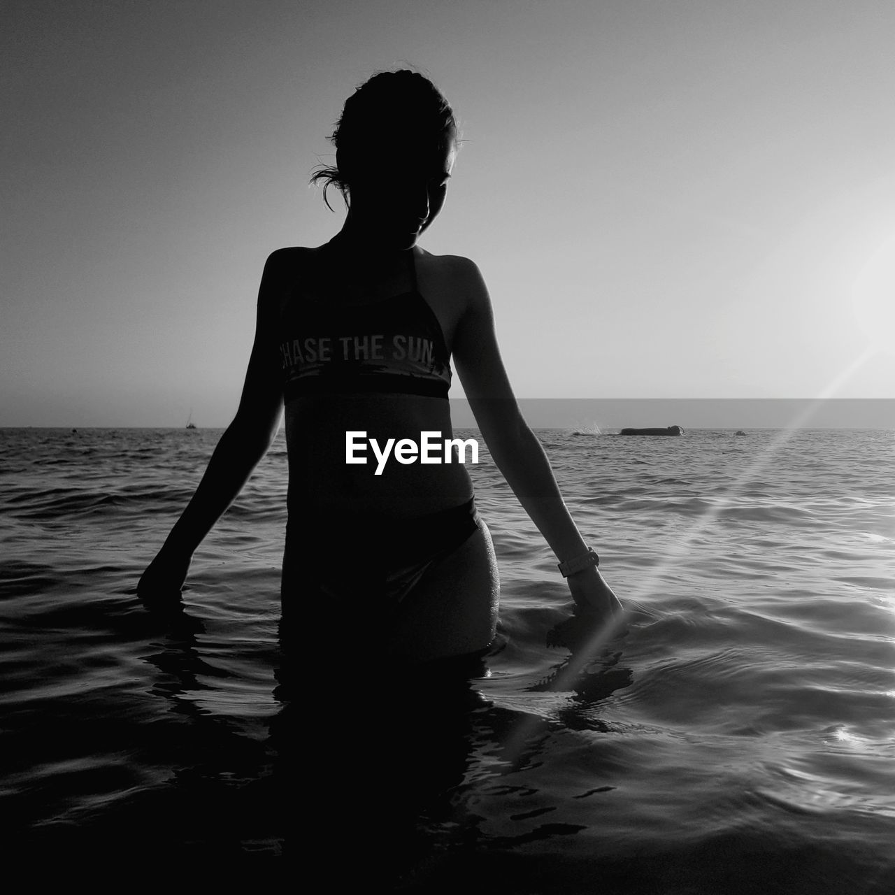 WOMAN STANDING AT SEA SHORE AGAINST SKY