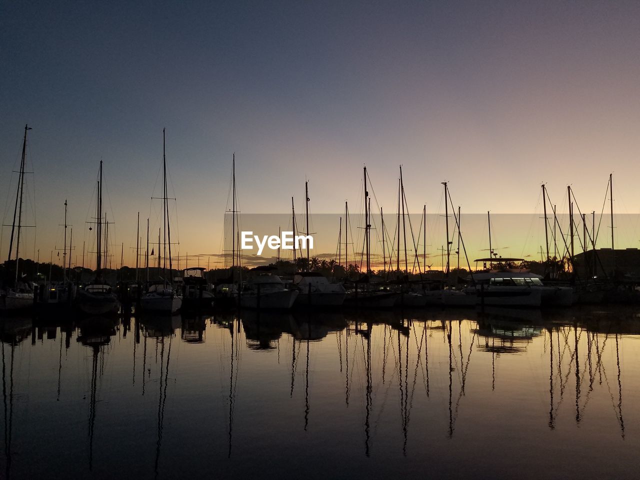 SAILBOATS MOORED AT HARBOR