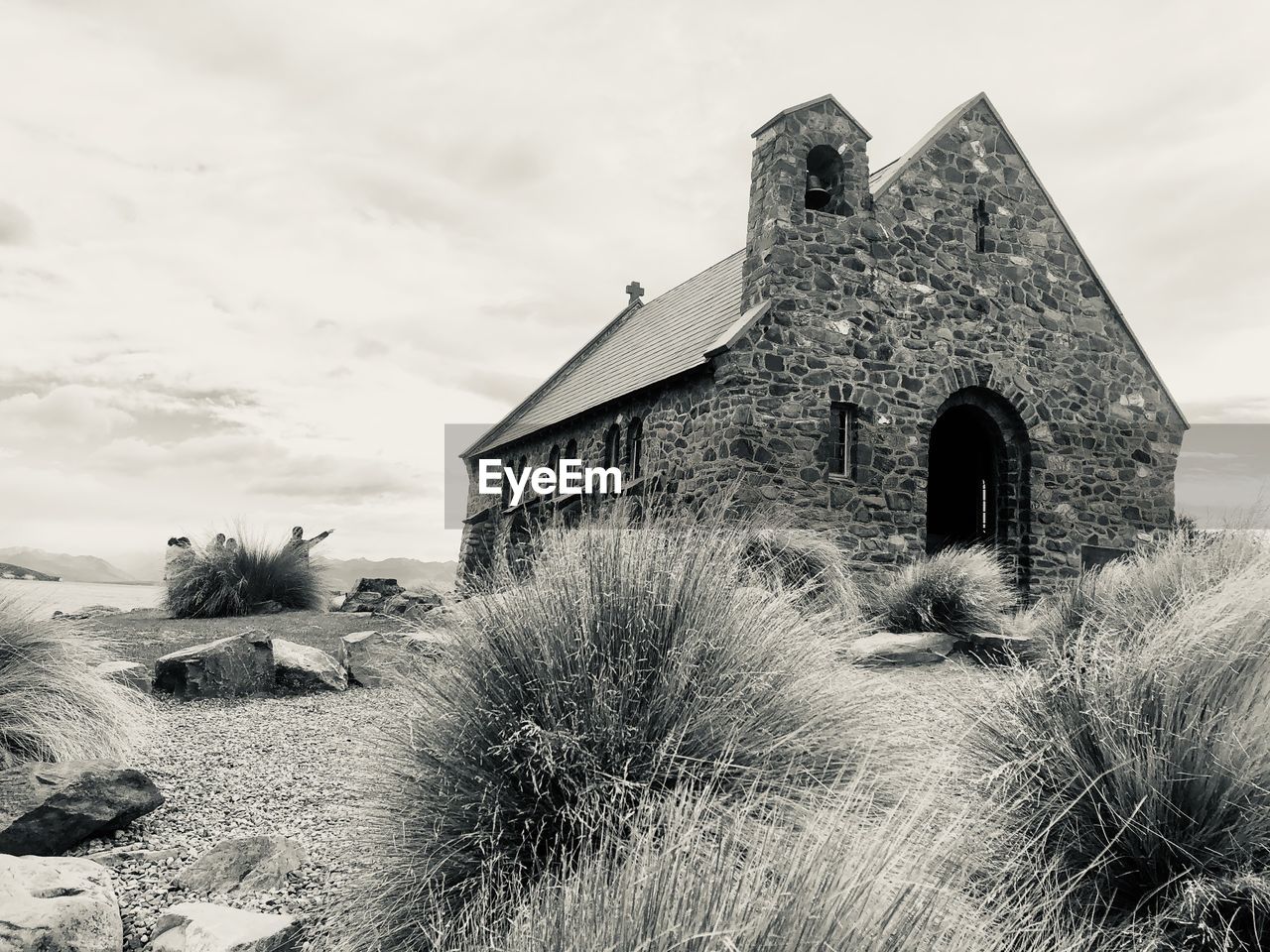 OLD BUILDING BY FIELD AGAINST SKY