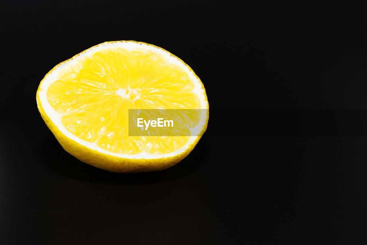 Close-up of lemon halved against black background