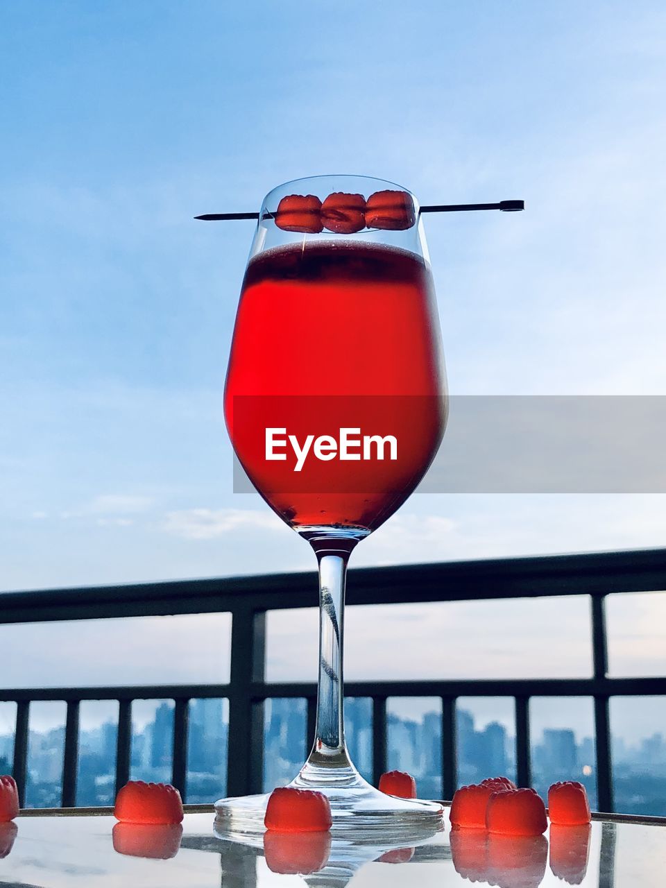 red, food and drink, refreshment, drink, glass, alcohol, sky, nature, cocktail, no people, wine glass, drinking glass, day, household equipment, blue, soft drink, water, wine, food, outdoors, freshness, table, cloud, sea, holiday, vacation, fruit, railing, travel, trip, summer