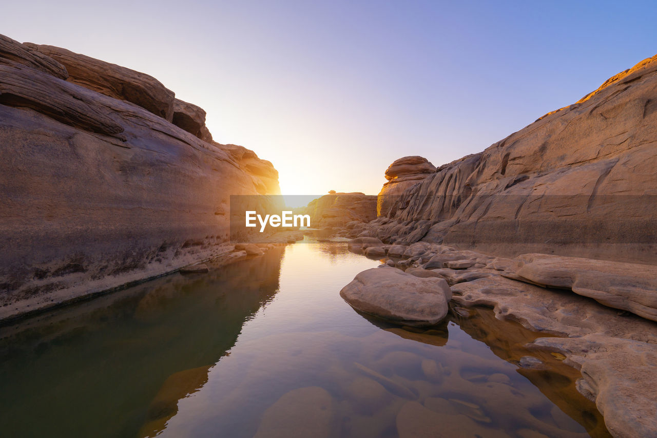 ROCKS IN WATER AT SUNSET