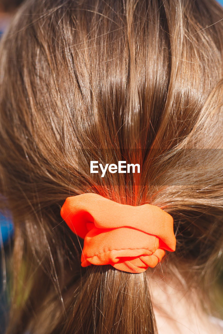 Rear view of woman with orange hair elastic