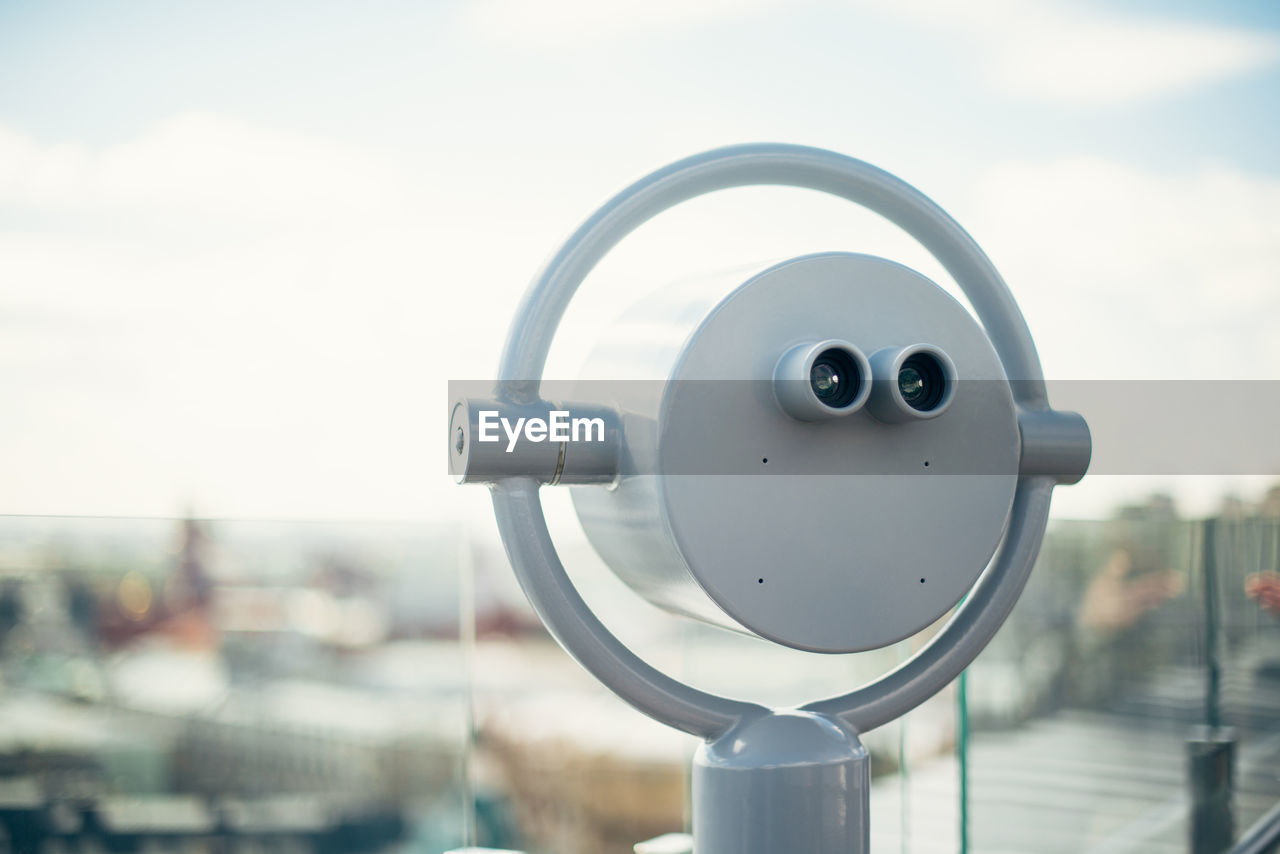 Close-up of coin-operated binoculars against sky