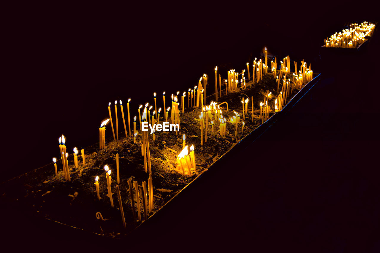 CLOSE-UP OF ILLUMINATED LIGHTING EQUIPMENT AGAINST CLEAR SKY