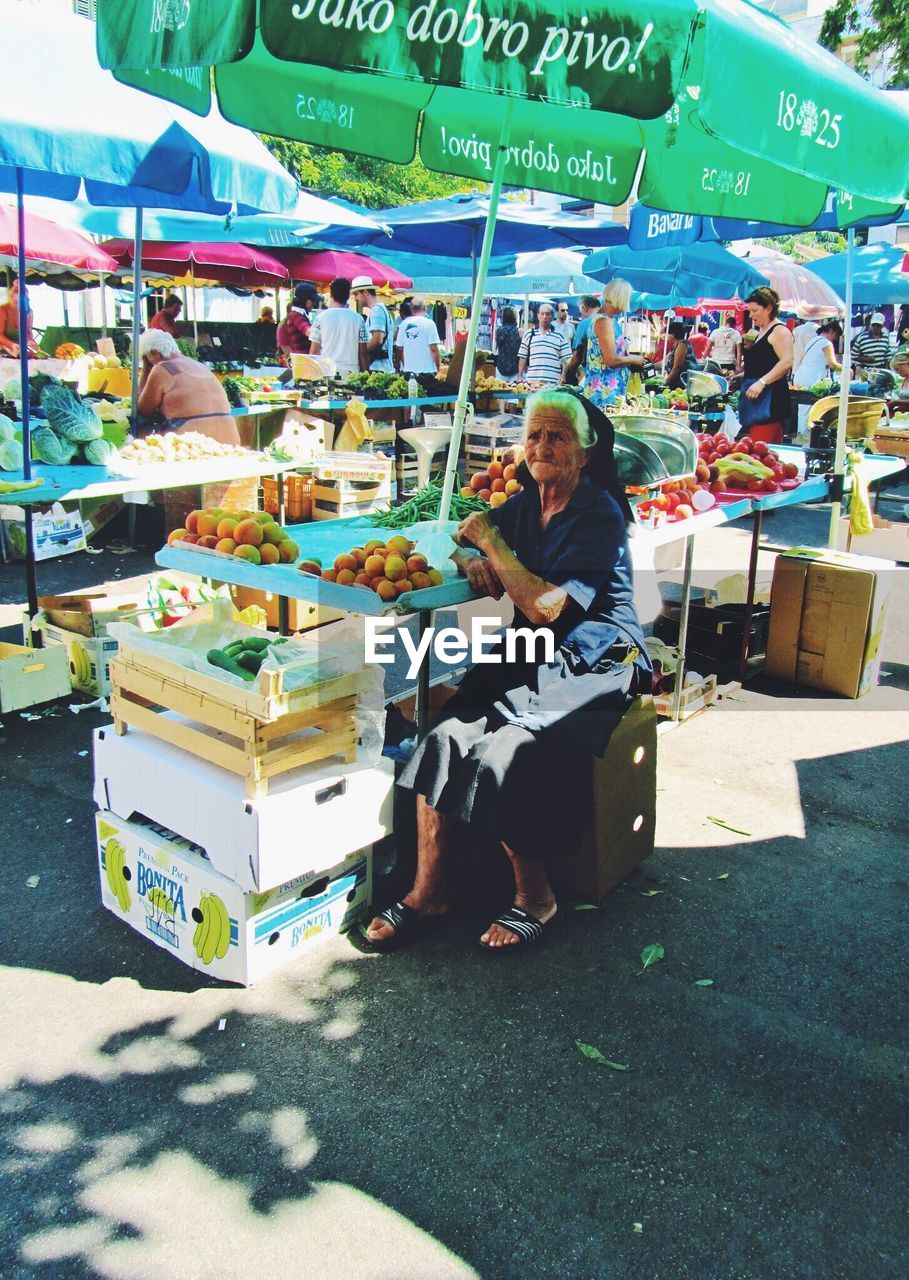 WOMAN SITTING IN MARKET