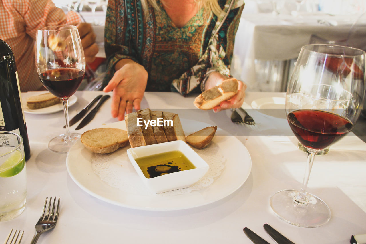 Midsection of woman sitting with meal at restaurant