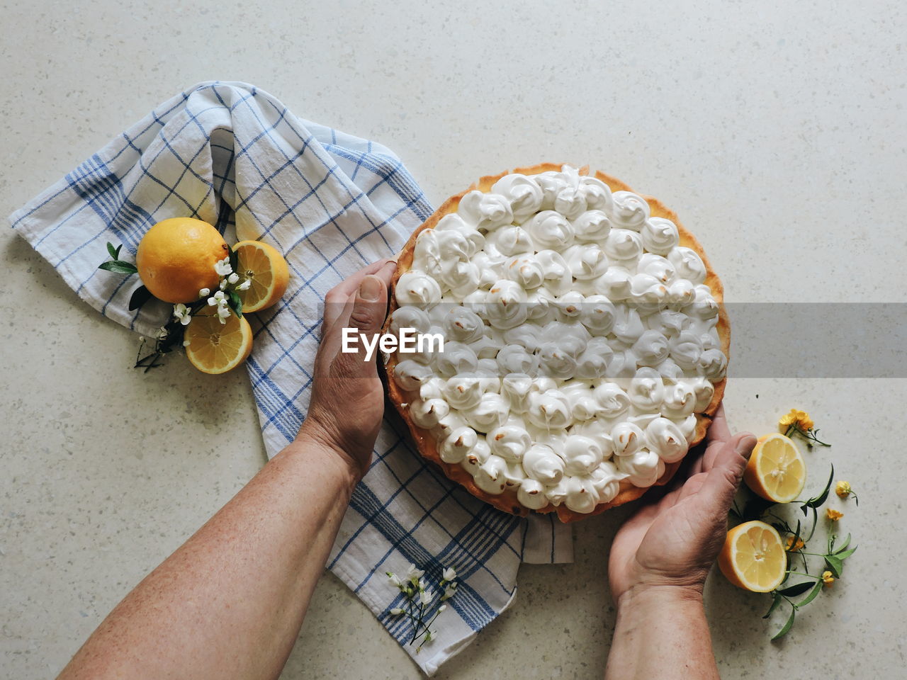 Cropped hands of woman placing cake on table