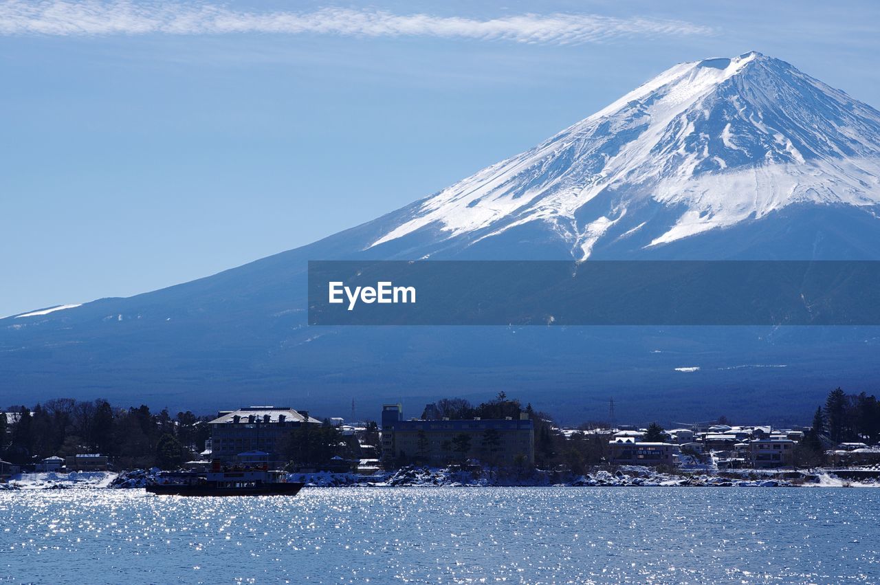 Scenic view of snow covered mountain against cloudy sky