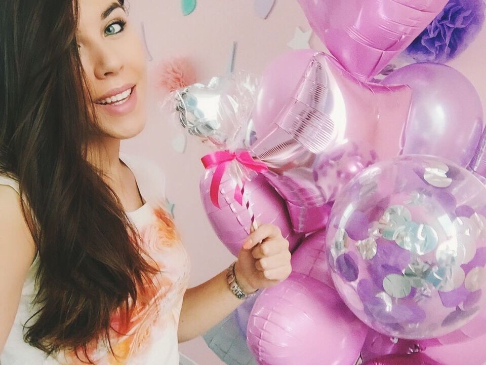 PORTRAIT OF YOUNG WOMAN HOLDING PINK BALLOON