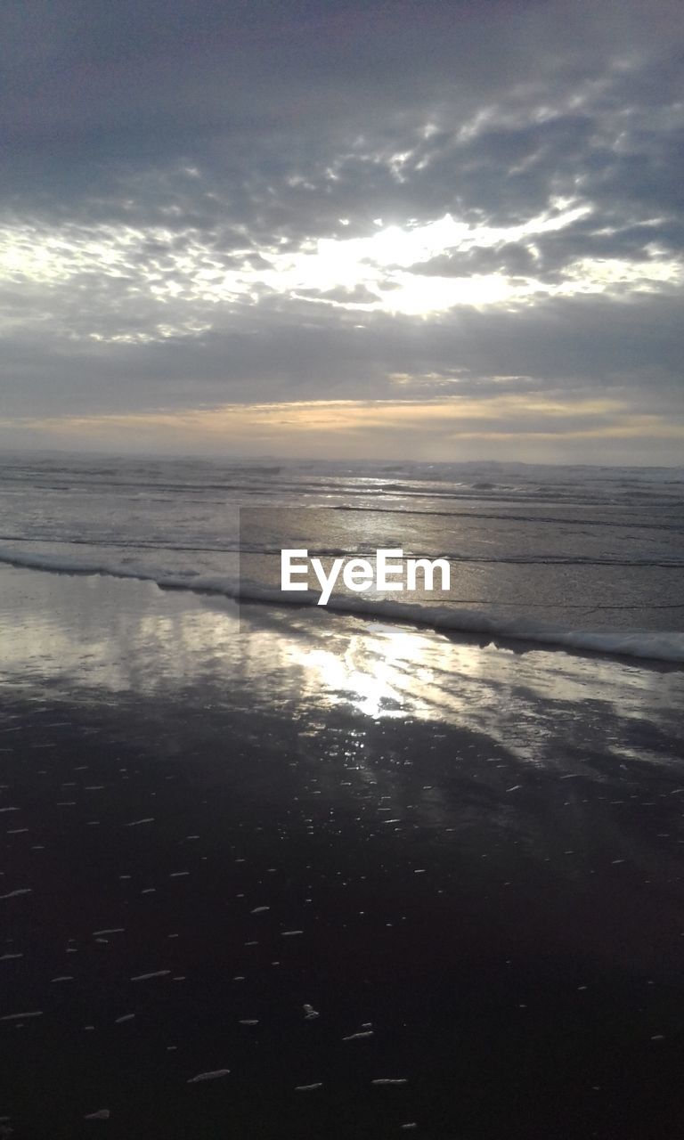 SCENIC VIEW OF BEACH AGAINST SKY AT SUNSET