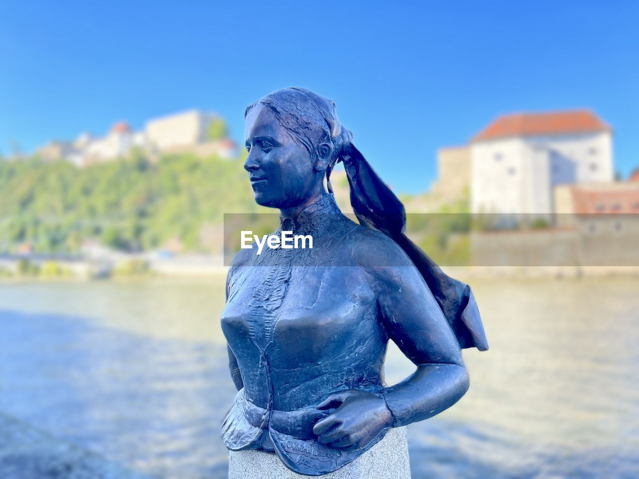 blue, water, statue, architecture, nature, sky, focus on foreground, day, monument, sculpture, built structure, representation, person, outdoors, human representation, sea, clear sky, one person, building exterior, city, adult, art, travel destinations, human face, vacation