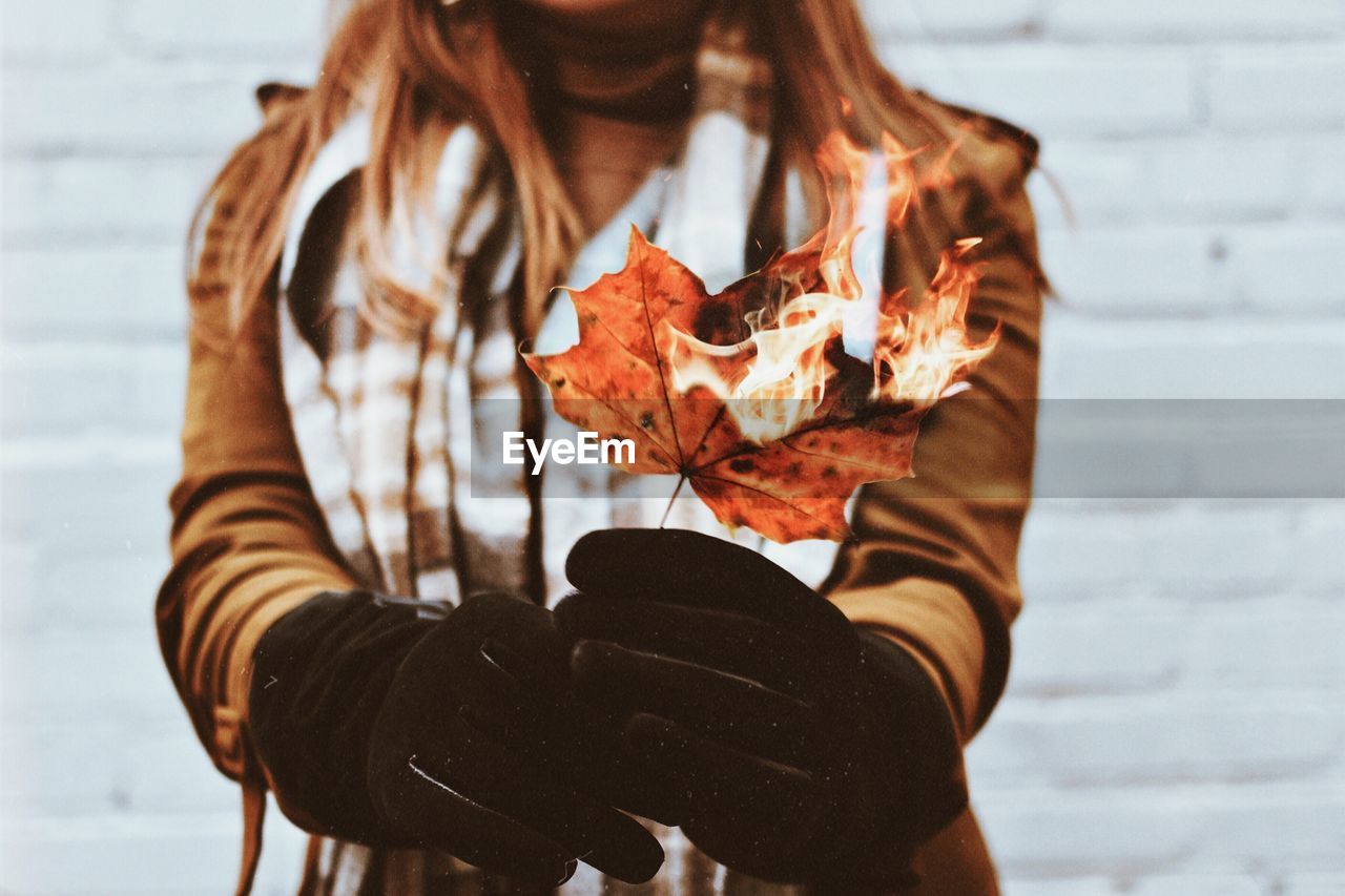 Midsection of woman holding burning leaf