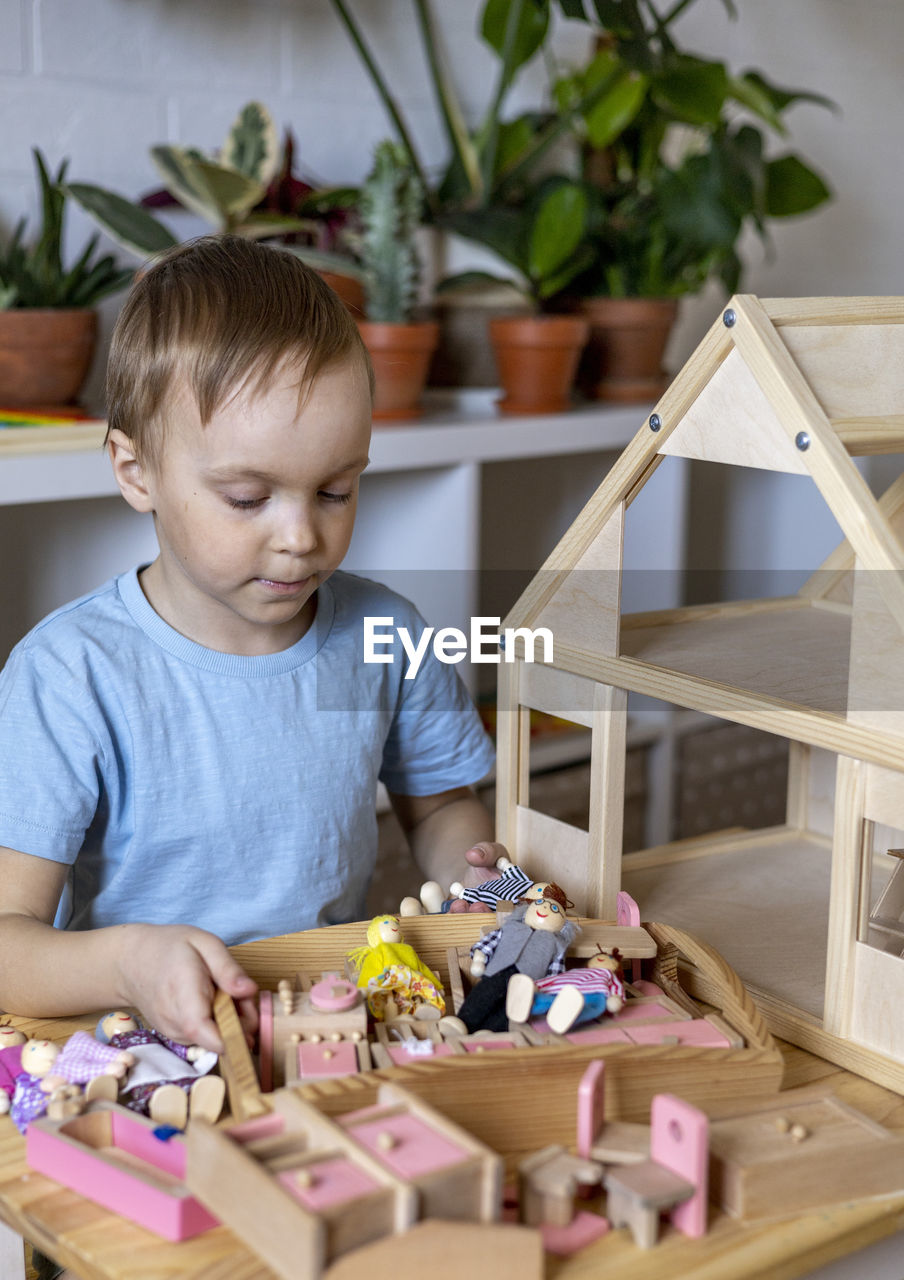 Boy playing with wooden toy at home