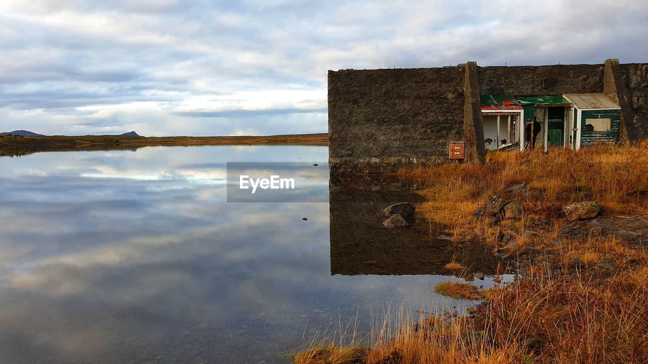 Reflection of building on lake against sky