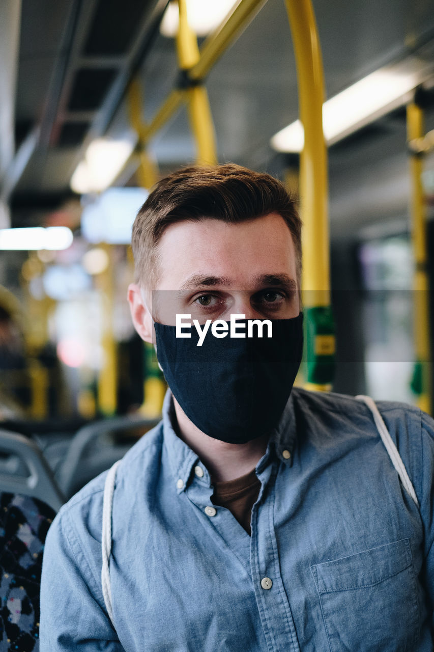 Portrait of man wearing mask in train