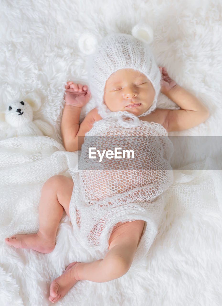 Cute baby girl lying on bed at home