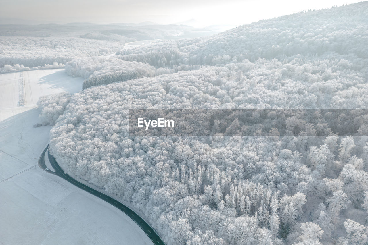 Aerial view of road going through snow covered landscape