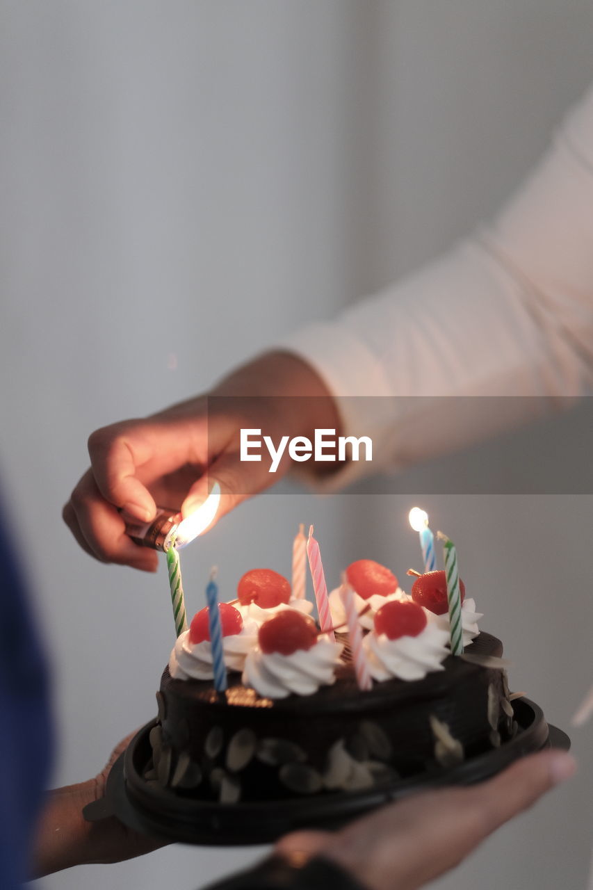 Cropped hand of person holding birthday cake