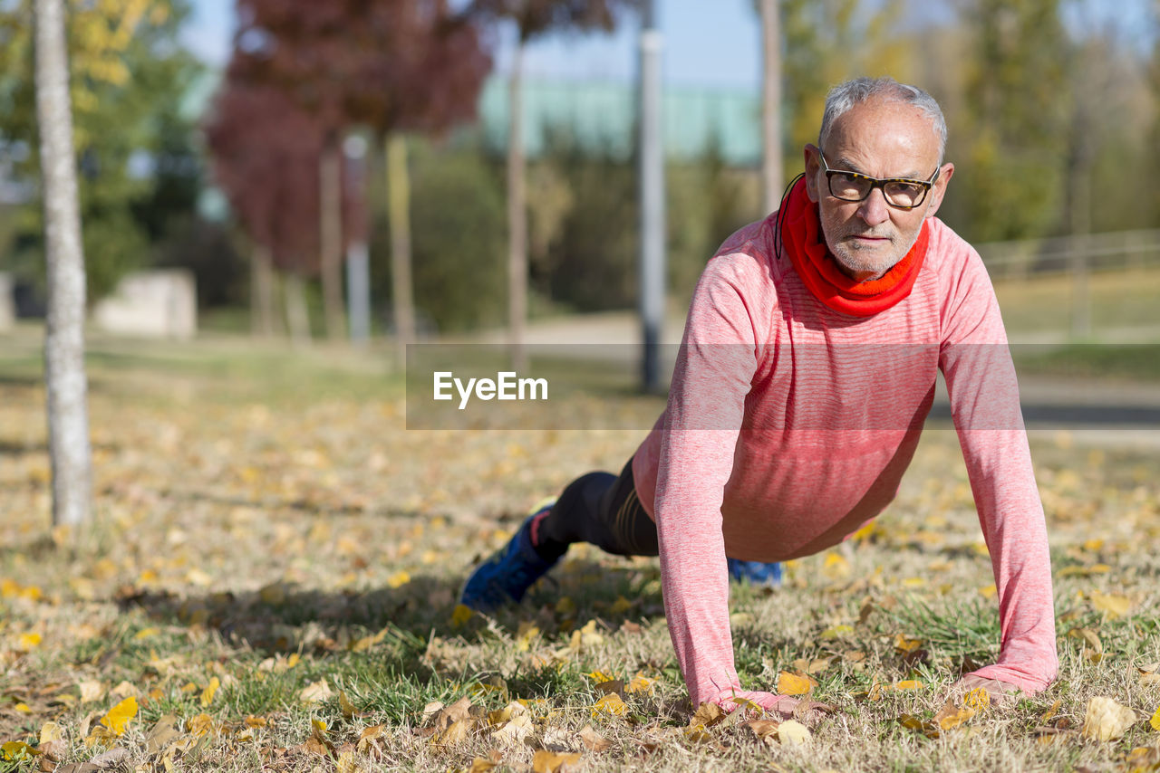 Senior man exercising on field at park