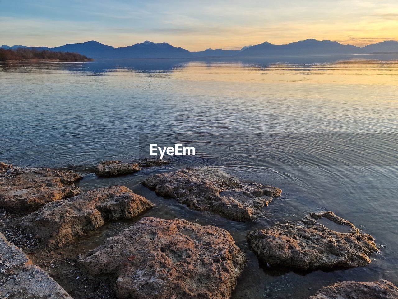water, sky, scenics - nature, beauty in nature, shore, sea, landscape, land, mountain, nature, environment, tranquility, coast, body of water, sunset, rock, tranquil scene, reflection, travel destinations, travel, cloud, beach, no people, horizon, outdoors, sun, ocean, bay, tourism, mountain range, idyllic, sunlight, day, non-urban scene, reservoir, dusk, coastline, twilight