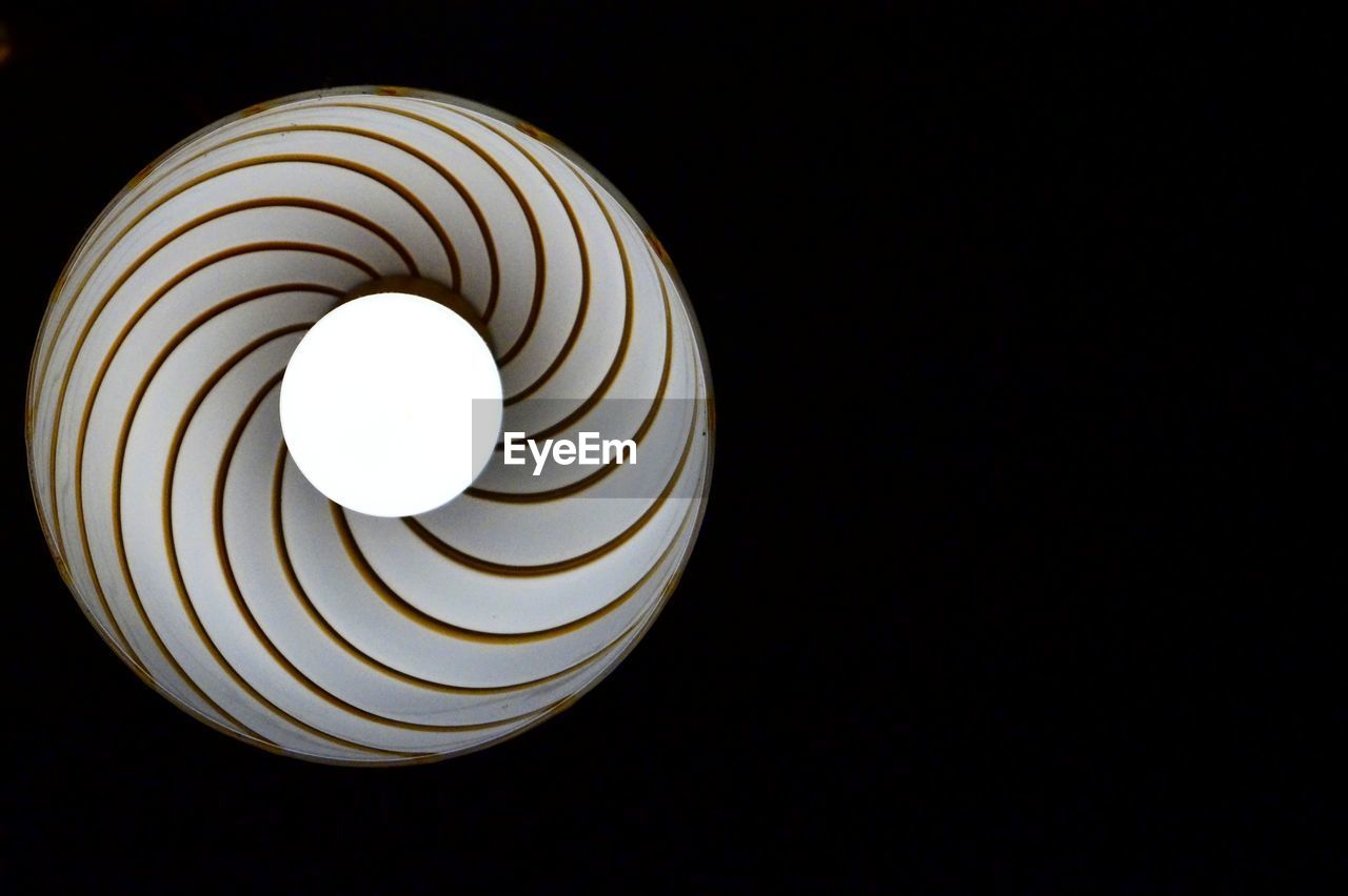 Low angle view of illuminated light bulb against black background