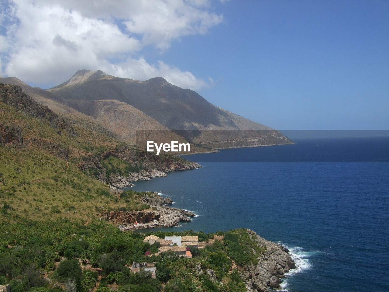 Scenic view of sea and mountains against sky