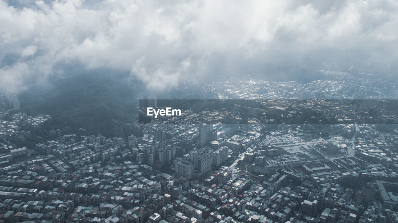 Aerial view of buildings in city against sky